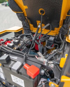 Compartiment moteur ouvert d’une mini-pelle avec filtres et points de contrôle des niveaux